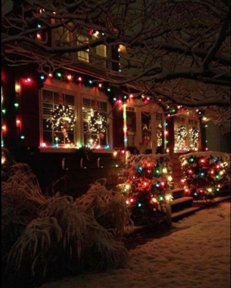 a house covered in christmas lights with snow on the ground