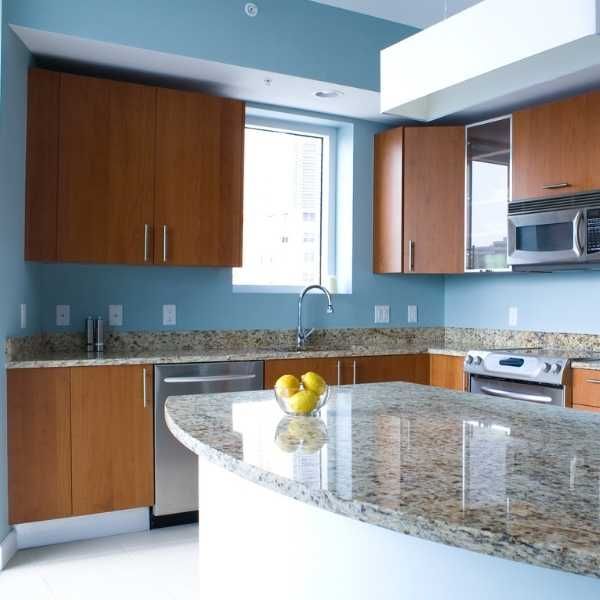 an empty kitchen with granite counter tops and wooden cabinets