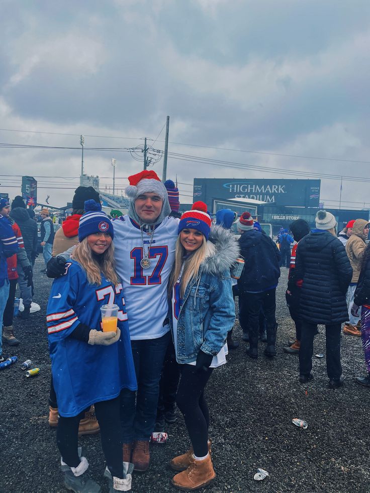 two people standing next to each other at a football game