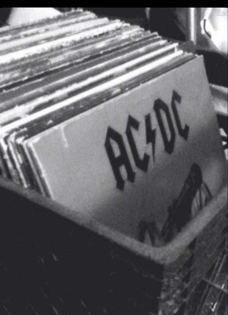 an old record player sitting on top of a wooden floor next to a pile of records