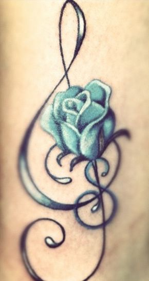 a blue rose tattoo on the side of a woman's thigh, with swirls around it