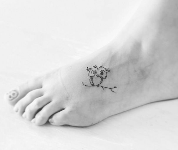 a small tattoo on the foot of a person with an owl sitting on top of it