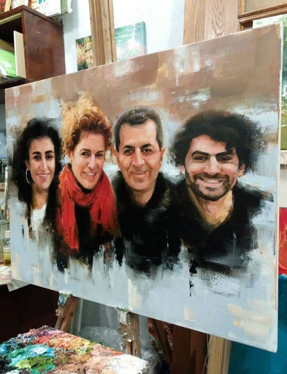 a painting of three people is being displayed in front of a table with paintbrushes