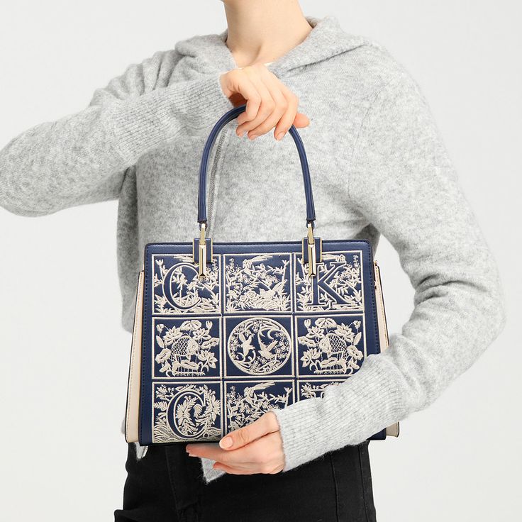 The Havilah Embroidery Medium Tote Bag is the perfect choice for a woman who wants something that is both stylish and functional. It has ample space for your necessities but will still look slim and stylish. The embroidery design adds a unique touch to show your great fashion sense. Now available in navy blue, claret, and beige. Luxury Embroidered Top Handle Shoulder Bag, Luxury Embroidered Handheld Shoulder Bag, Ladies' Floral Embroidery Top Handle Bag, Elegant Embroidered Shoulder Bag With Double Handle, Elegant Embroidered Double Handle Shoulder Bag, Luxury Embroidered Travel Bags, Elegant Embroidered Tote Satchel, Rectangular Satchel With Removable Pouch, Blue Embroidered Shoulder Bag For Shopping