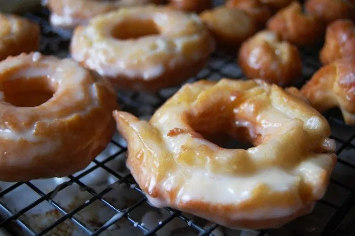 several glazed donuts sitting on a cooling rack