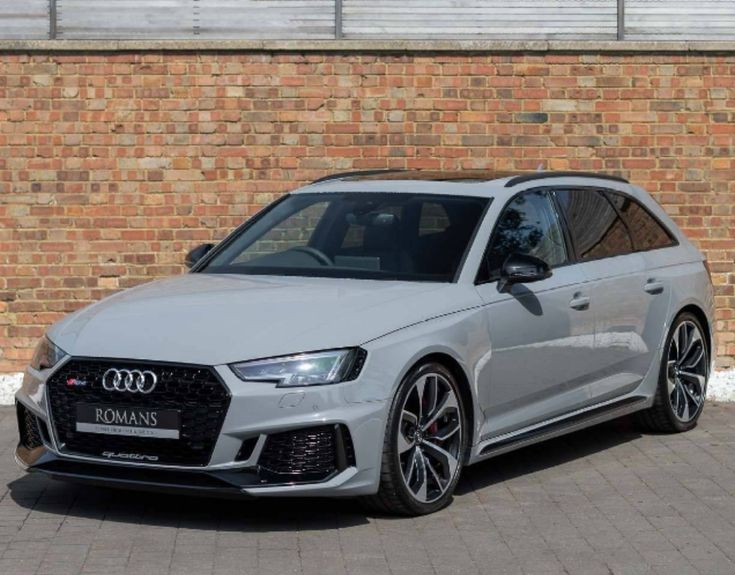 an audi rs3 is parked in front of a brick wall