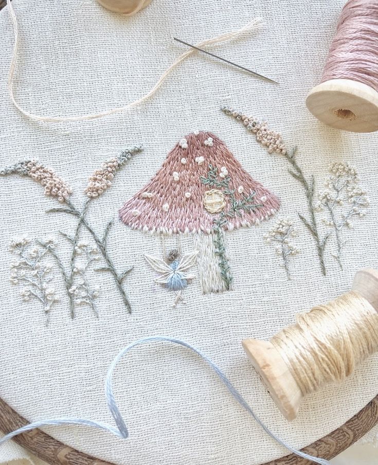 a close up of a piece of embroidery on a table with thread and spools