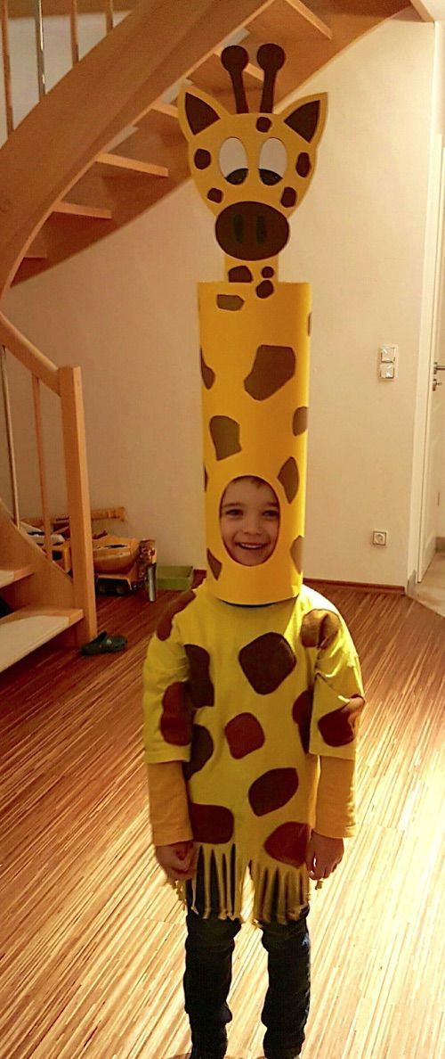 a young child wearing a giraffe costume standing in front of a stair case