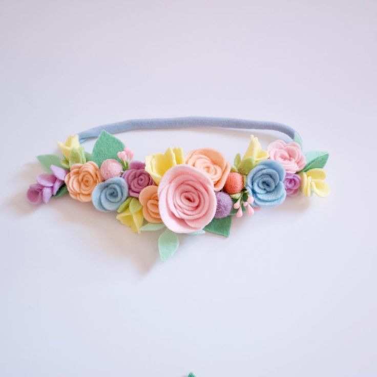 a headband made out of felt flowers and leaves