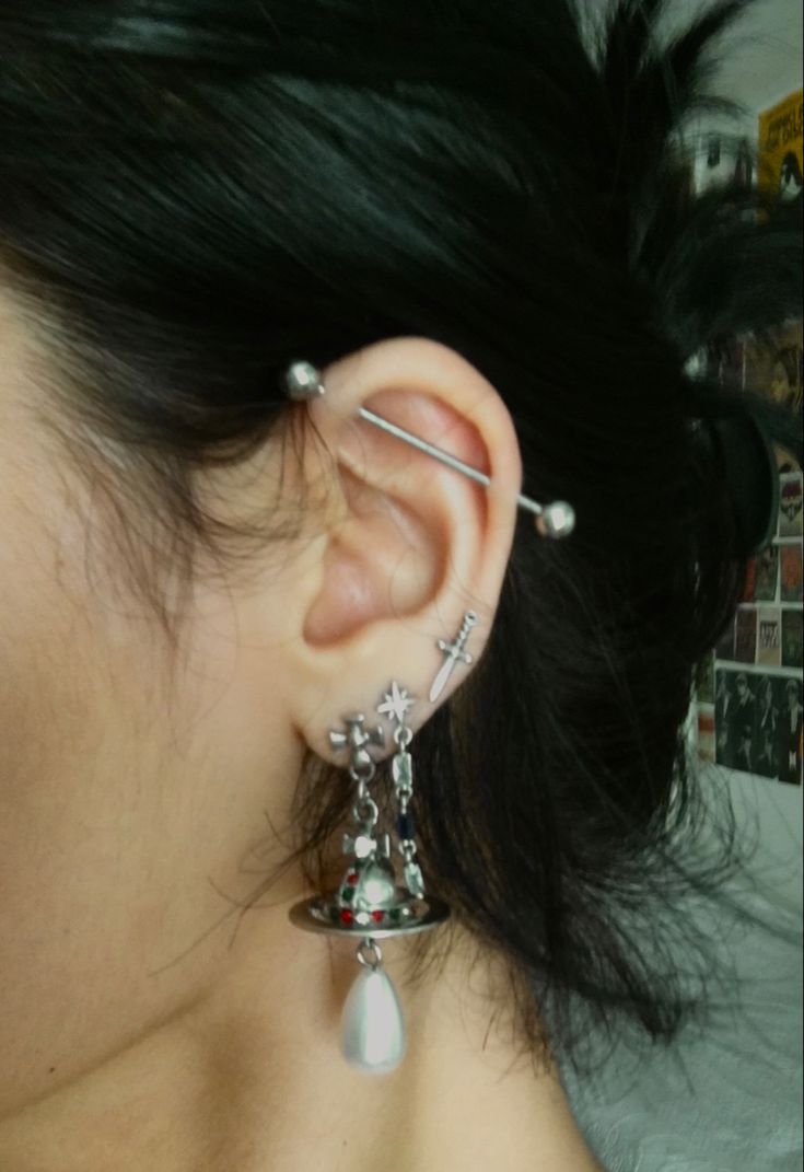 a close up of a person with ear piercings on their ears and wearing jewelry