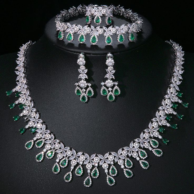 Experience the epitome of elegance with our Luxury Emerald Bridal Jewelry Sets. These exquisite pieces feature captivating green emerald-like stones crafted from AAA Cubic Zirconia, meticulously set in a pendant necklace and coordinating earrings. Designed to enhance your allure at any special occasion, from weddings to glamorous parties and elegant dinner events, these sets embody a timeless sophistication. Style: TRENDY Shape\pattern: Geometric Occasion: Wedding Metals Type: Copper Alloy Mater Dazzling Green Emerald Necklace For Formal Occasions, Green Sparkling Stones Jewelry Sets For Party, Cubic Zirconia Emerald Necklace For Wedding, Dazzling Green Jewelry With 17 Jewels, Formal Silver Jewelry Sets With Emerald, Green Crystal Jewelry Sets With Sparkling Stones, Green Emerald Jewelry With Sparkling Stones, Formal Silver Emerald Jewelry Sets, Dazzling Green Emerald Necklace