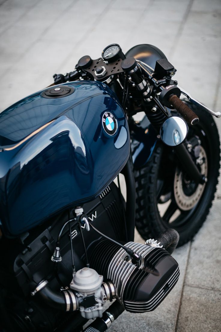 a blue motorcycle parked on the sidewalk