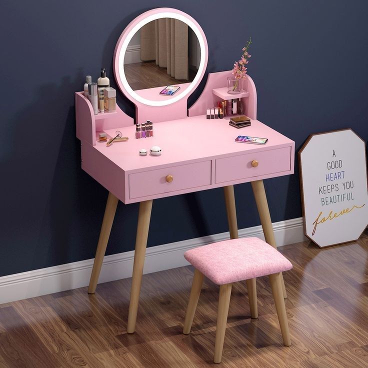 a pink vanity table with mirror and stool