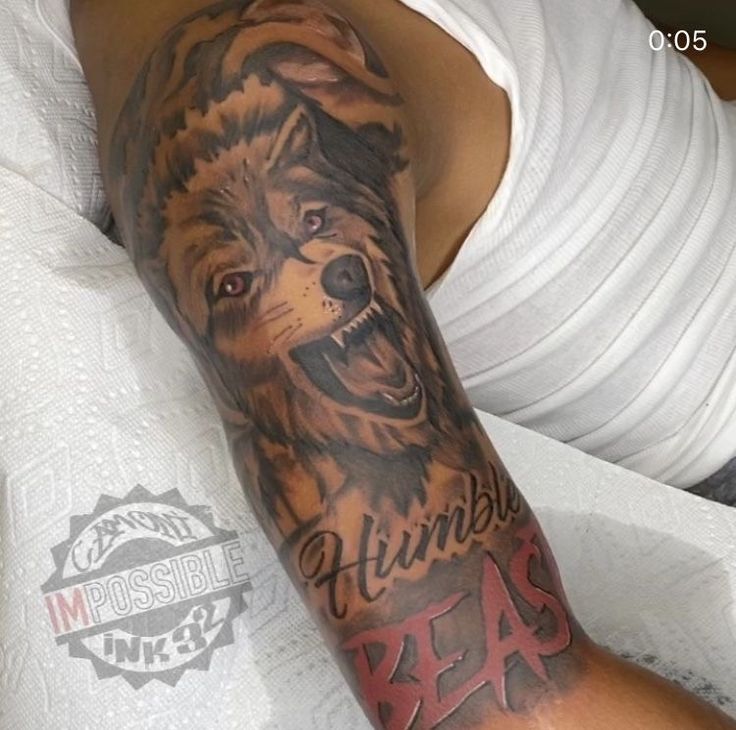 a man with a wolf tattoo on his arm