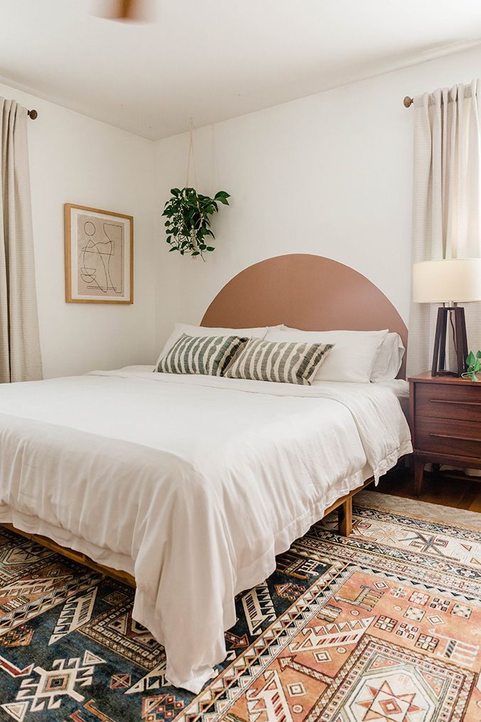 a bedroom with a bed, rug and two lamps on either side of the bed