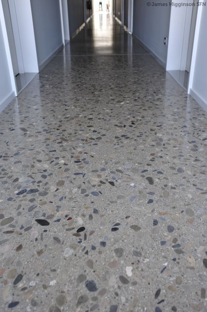 an empty hallway with white walls and grey flooring is pictured in this image from the inside