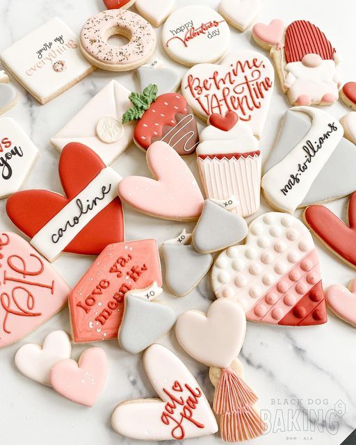 valentine's day cookies are arranged on a marble countertop with writing and hearts