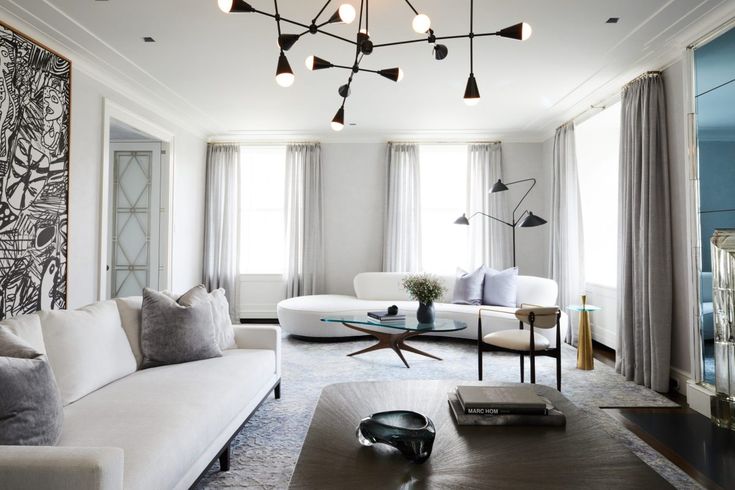 a living room filled with white furniture and lots of windows