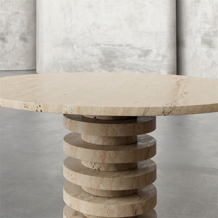 a round table made out of marble stacked on top of each other in an empty room