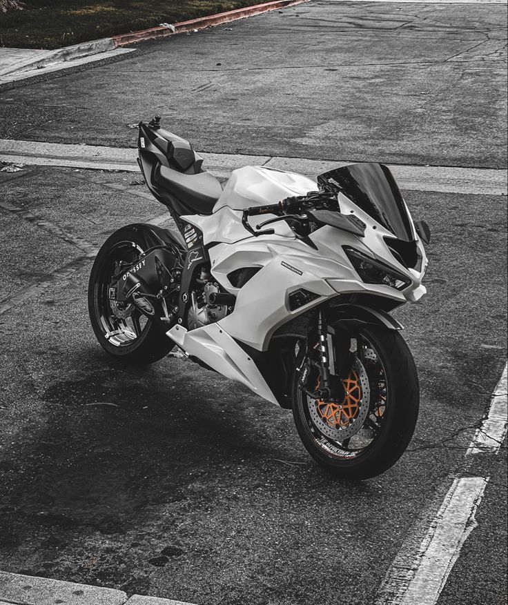 black and white photograph of a motorcycle parked in a parking lot with no one around