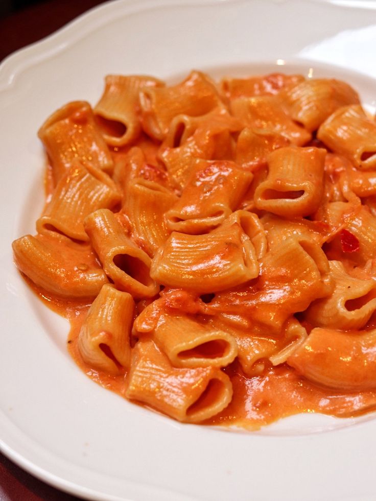 a white plate topped with pasta covered in sauce