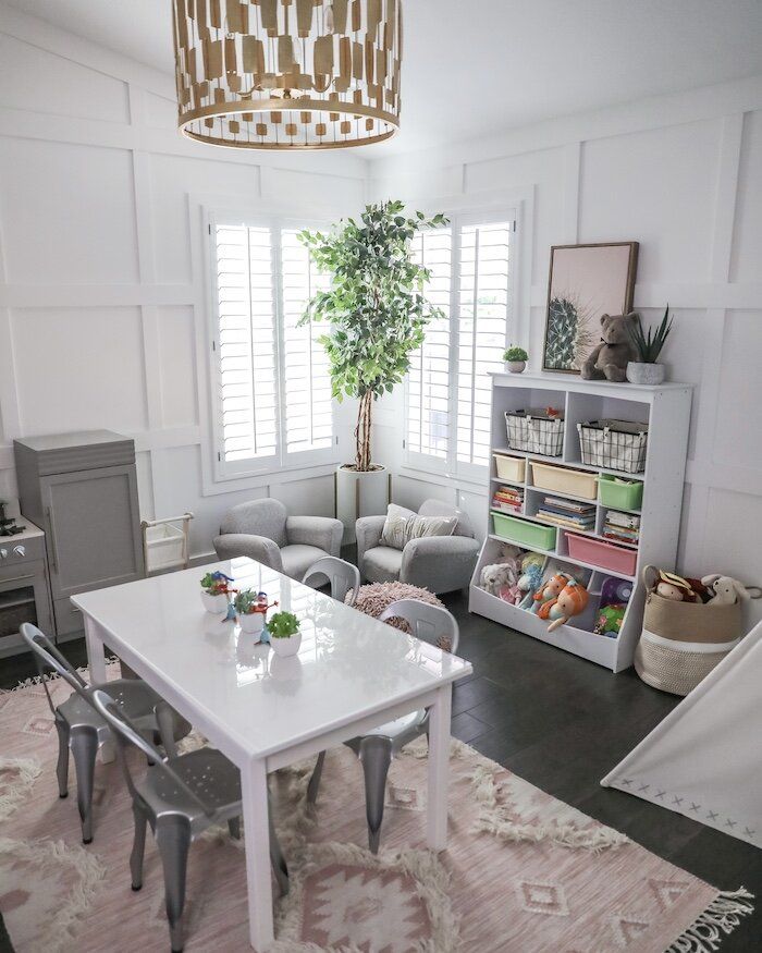 a living room filled with furniture and a white dining table surrounded by gray chairs next to a bookshelf