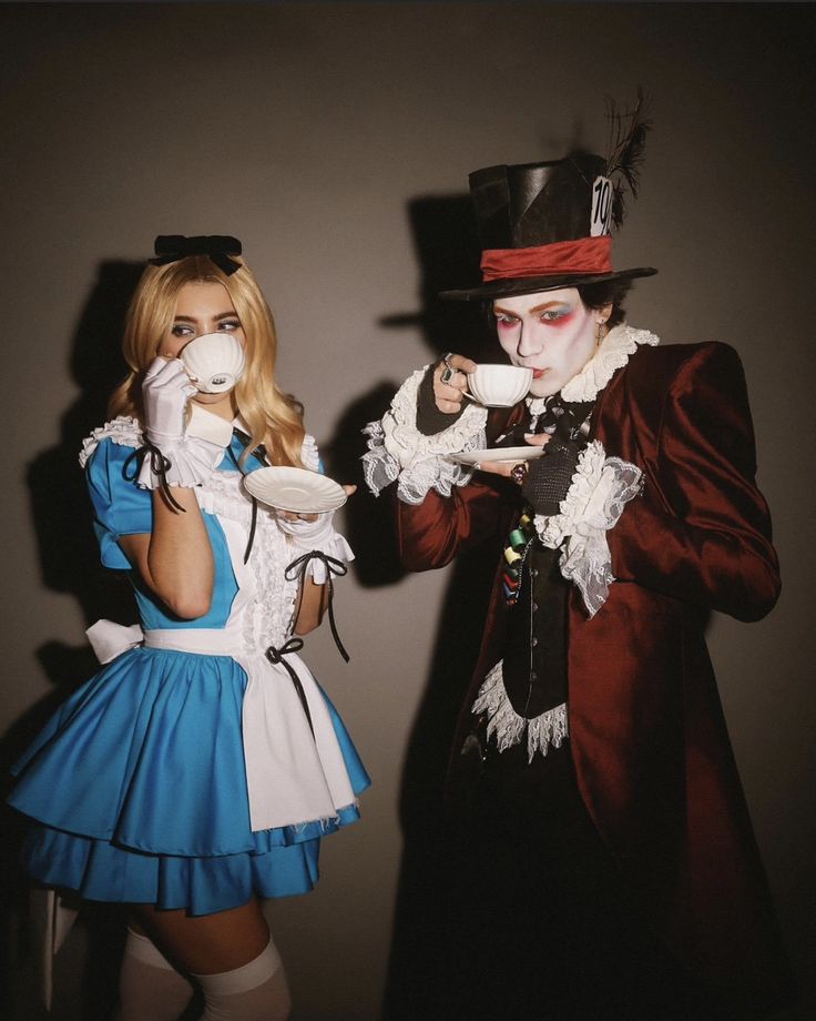 two people dressed up as alice and the mad hatter, one holding a tea cup