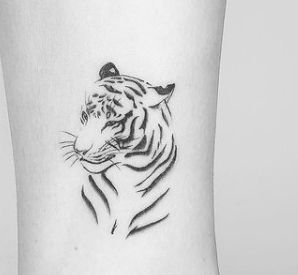 a black and white tiger tattoo on the ankle, with an animal's head