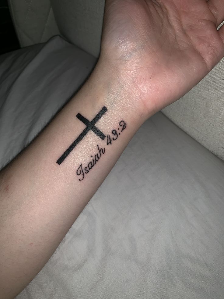 a person's arm with a cross tattoo on it and the words faith 432 written in black ink