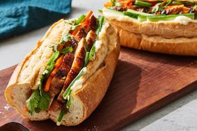 two sandwiches sitting on top of a wooden cutting board