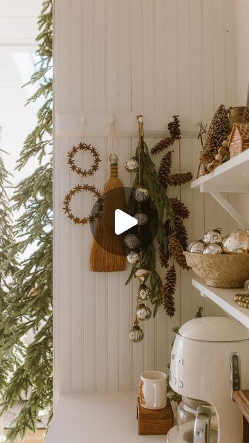 the kitchen is decorated for christmas with wreaths and pine cones hanging on the wall