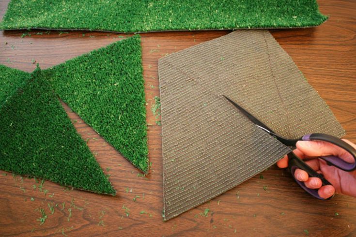 someone cutting grass with scissors on top of it and another piece of fabric in the background