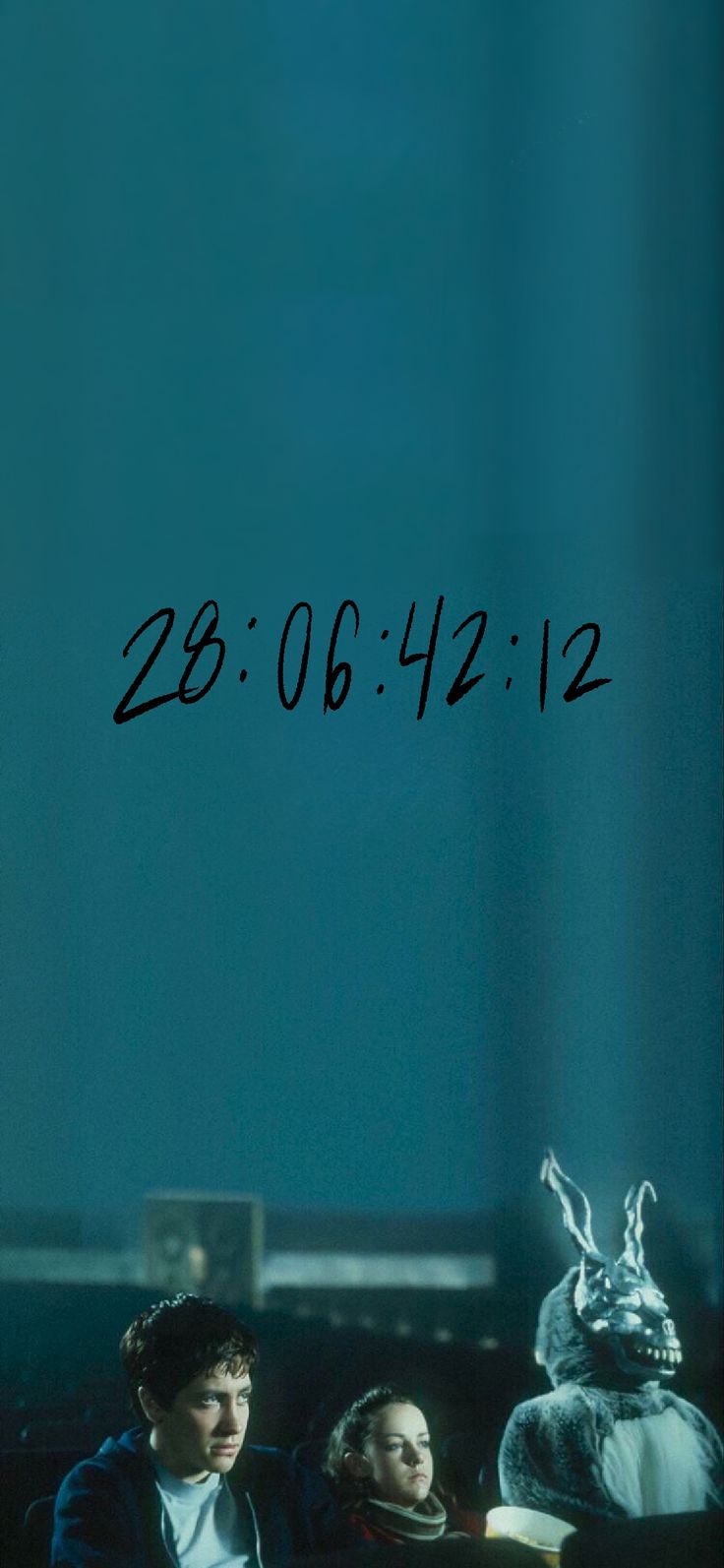 two people sitting next to each other in front of a blue wall with the date on it