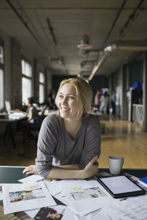 a woman sitting at a table with her arms crossed and coffee cup in front of her