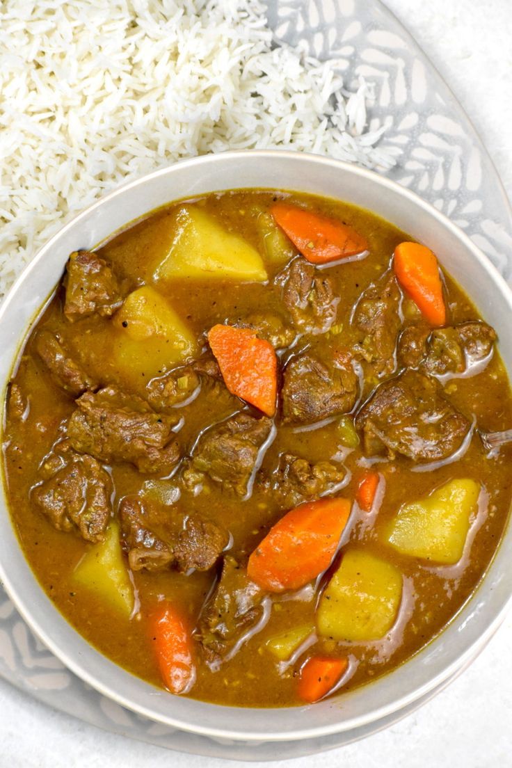 a white bowl filled with stew and carrots