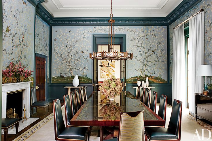 an elegant dining room with blue walls and floral wallpaper, along with black leather upholstered chairs