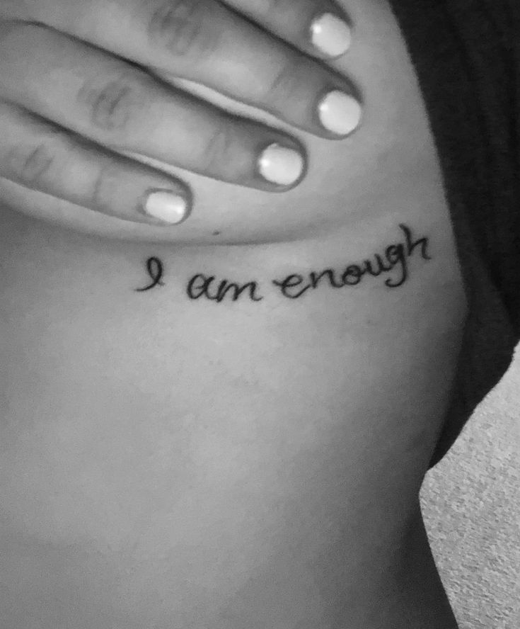 a woman's stomach with the words i am enough tattooed on her left side