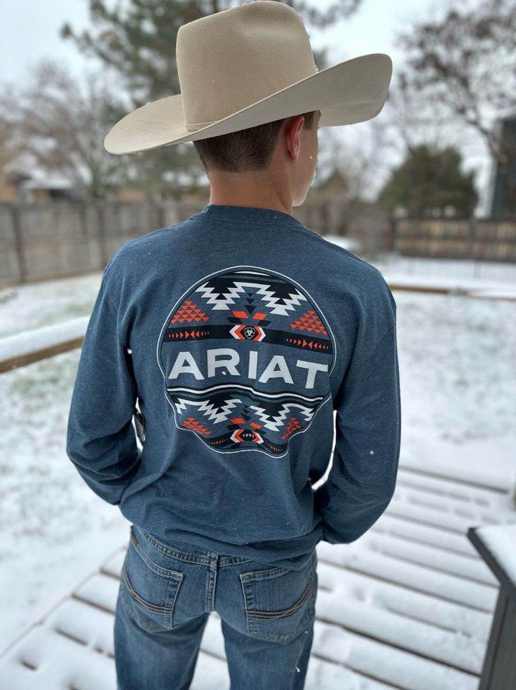 Men's Aztec Logo Graphic Tee by Ariat Heather blue, long sleeve graphic tee Front chest logo and a back design 52% cotton, 48% polyester Country Style Clothes Men, Farm Outfit Men, Mens Country Outfits, Cutesie Outfits, Western Outfits For Men, Country Boy Outfits, Outfits Guys, Country Graphic Tees, Cheetah Print Wallpaper