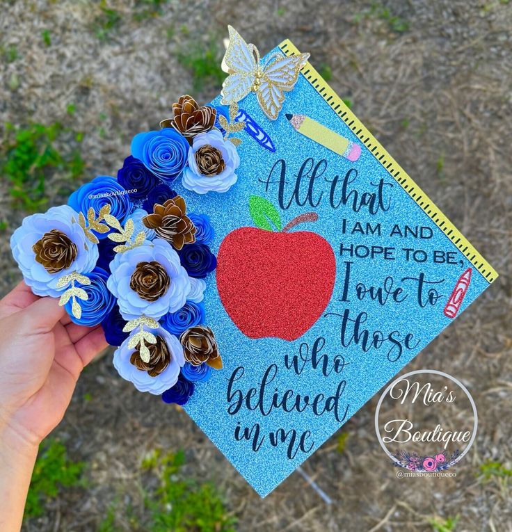 someone is holding up a blue graduation cap with flowers on it that says, i am and hope to be