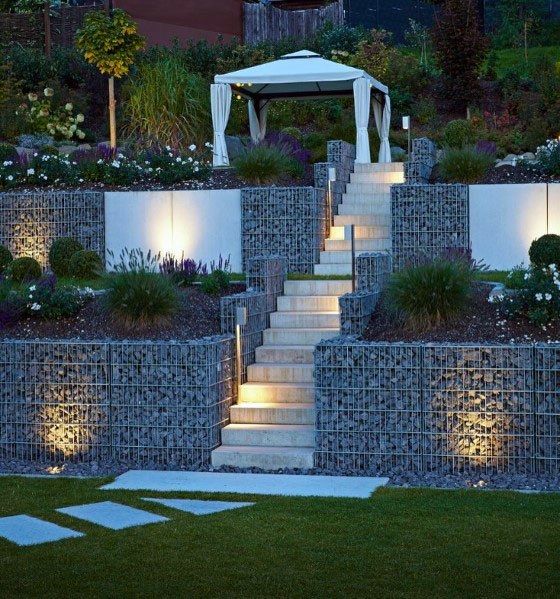 a set of steps leading up to a gazebo with lights on them and grass in the foreground