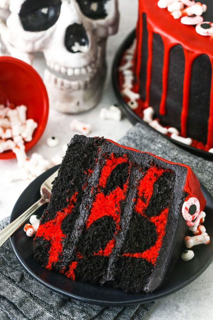 a slice of cake with red frosting and sprinkles is on a black plate