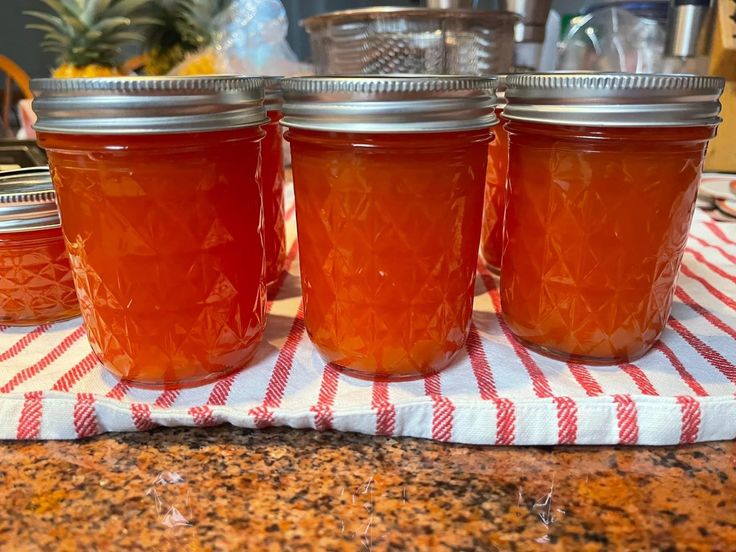 four jars filled with liquid sitting on top of a table