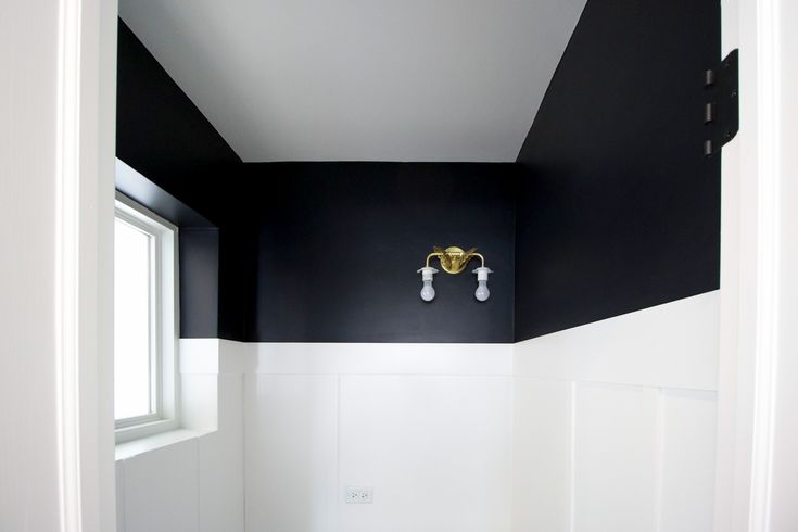 an empty bathroom with black and white walls