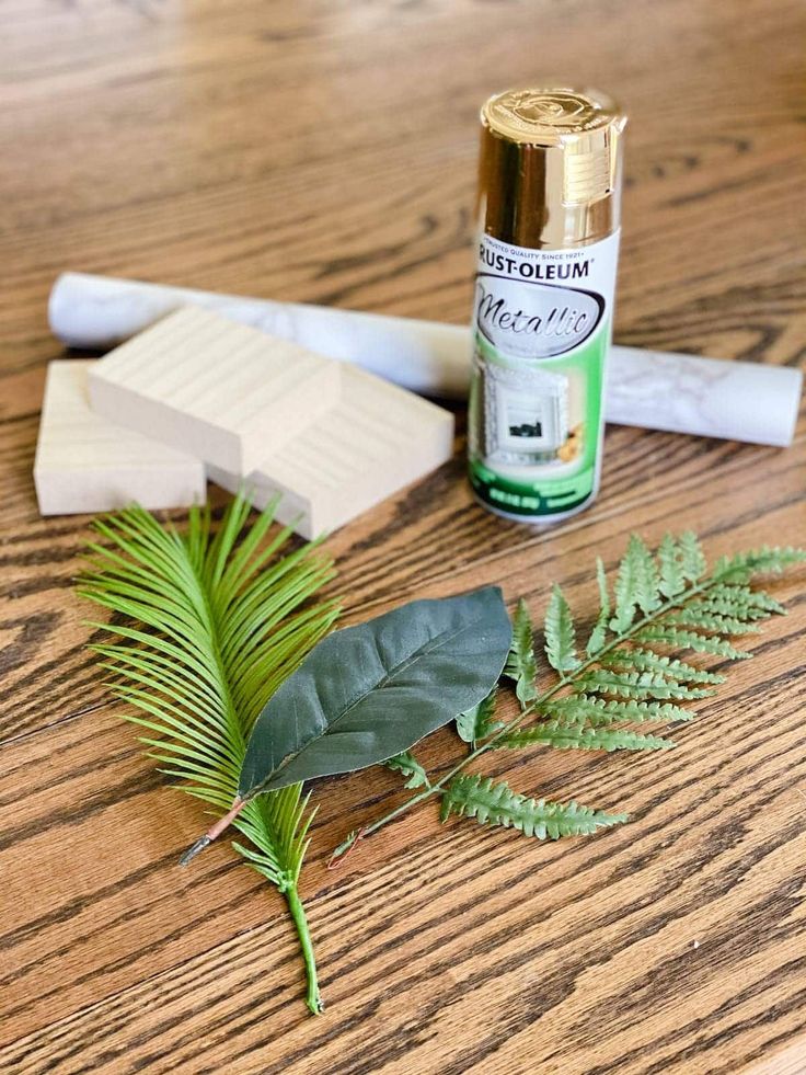 a wooden table topped with green leaves and glue