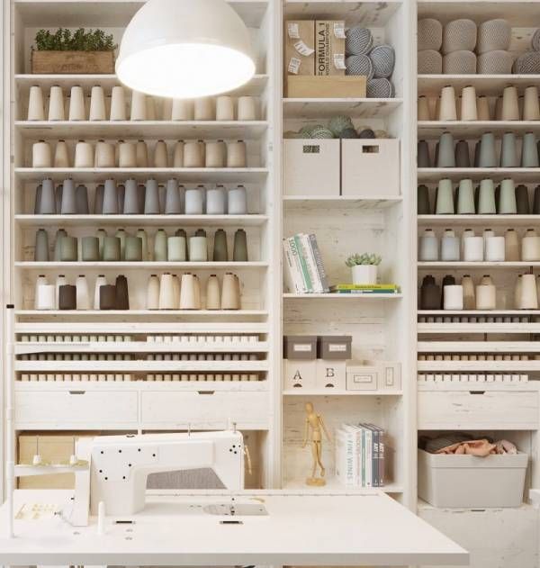 a sewing machine sitting on top of a table next to a white shelf filled with lots of crafting supplies