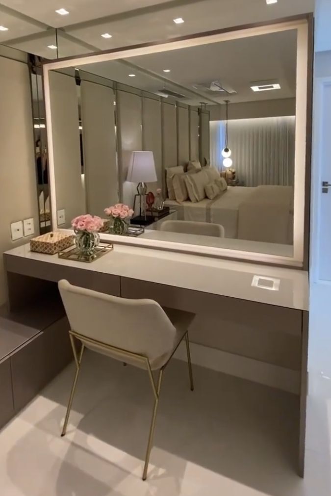 a chair sitting in front of a large mirror