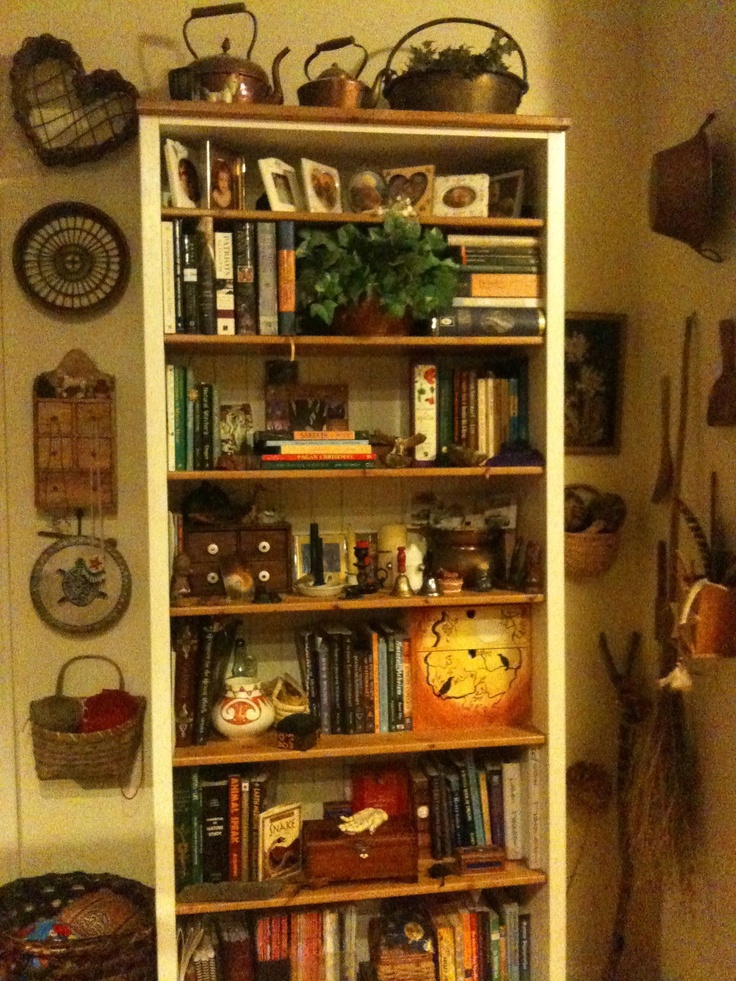 a bookshelf filled with lots of books in a living room next to a wall