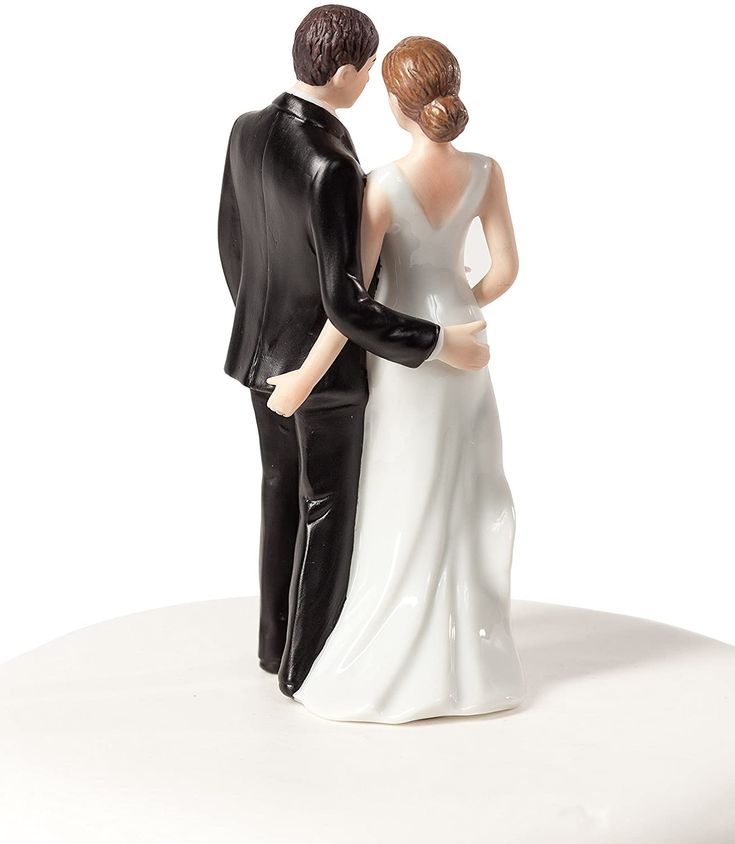 a bride and groom figurine on top of a cake