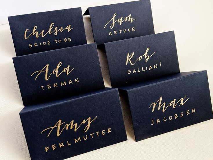 six place cards with gold ink on them