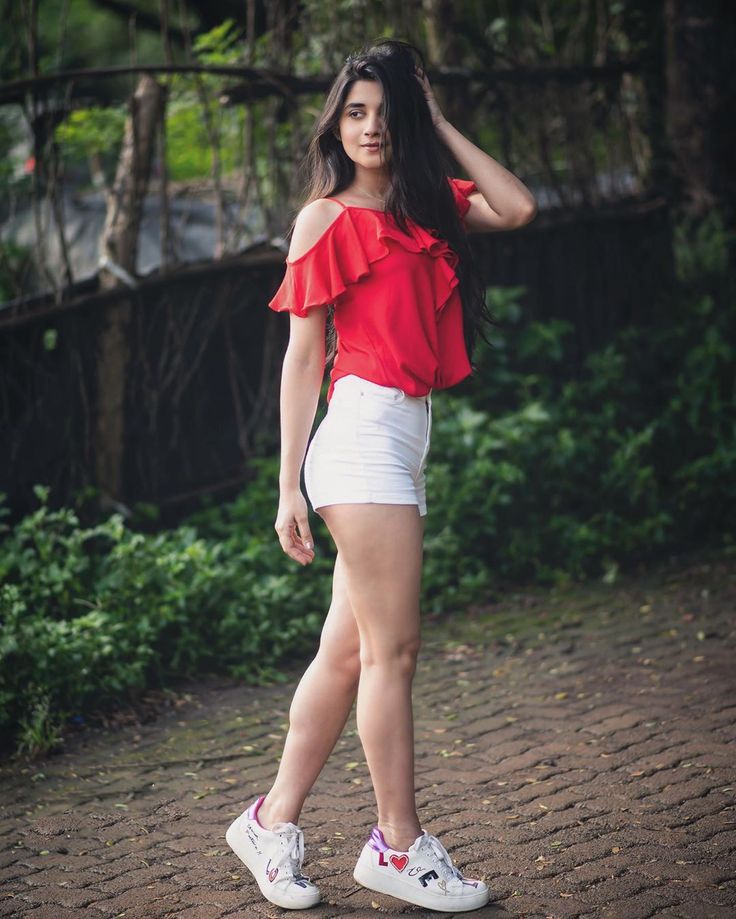 a woman in white shorts and a red top